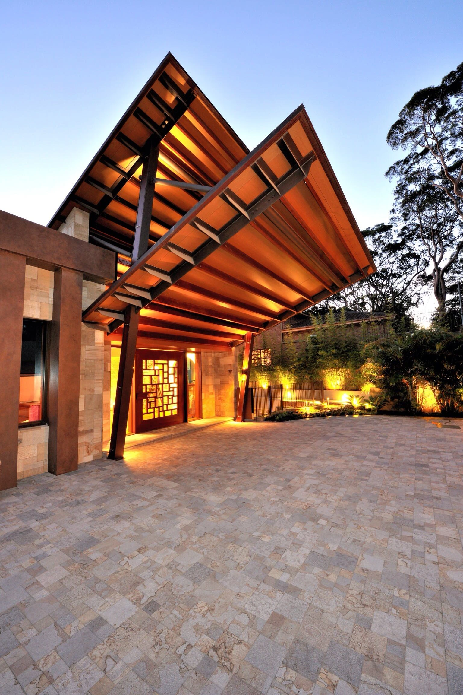 Elegant concrete driveway in Dallas TX with natural stone pattern and ambient lighting enhancing modern home entrance.